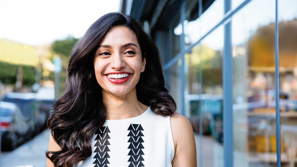Woman smiling confidently while representing discreet Invisalign clear aligner treatment