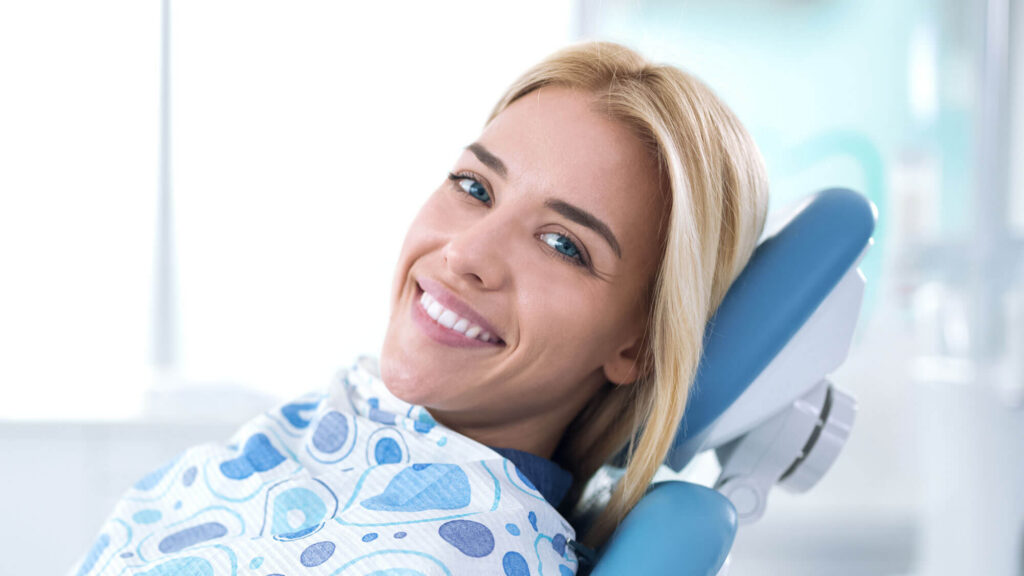 Patient smiling comfortably while seated in a dental chair for routine dental care