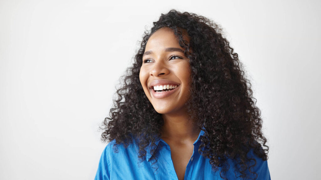 Woman smiling confidently with healthy teeth after maintaining good oral health