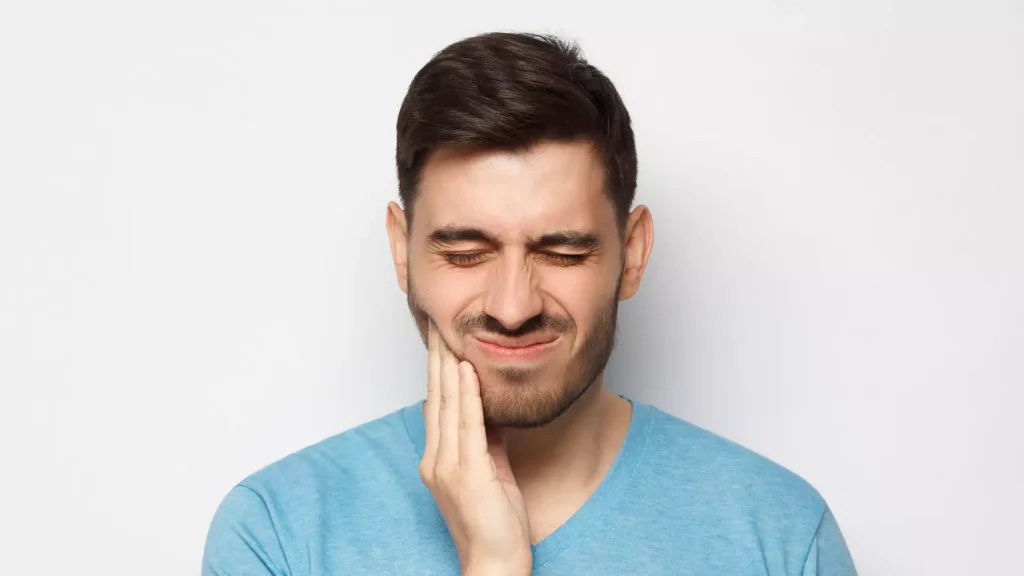 Man with severe tooth pain showing a possible sign that professional dental treatment is needed