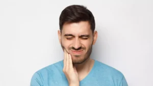Man with severe tooth pain showing a possible sign that professional dental treatment is needed