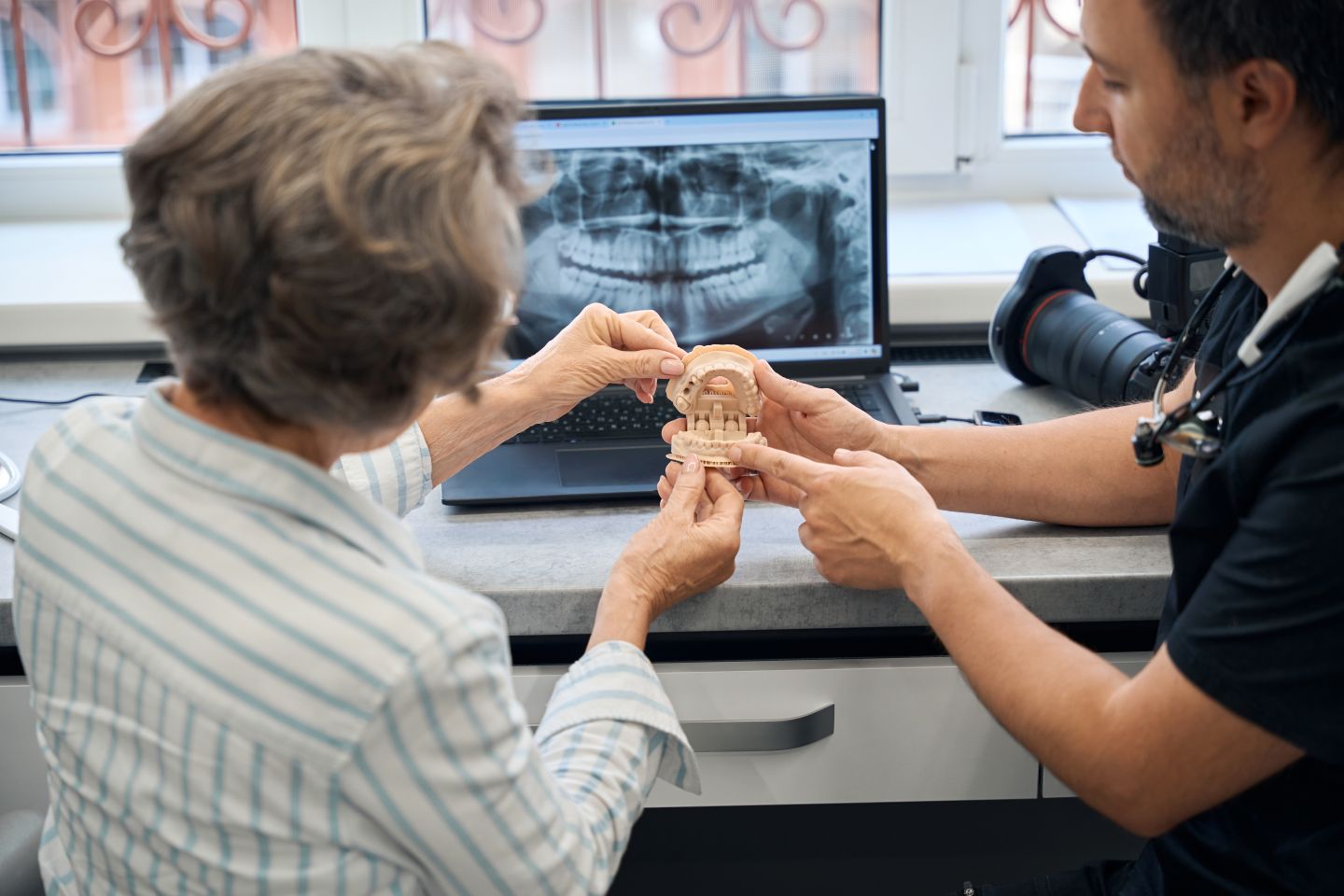 Dentist discussing digital dental imaging and personalized treatment planning with a patient
