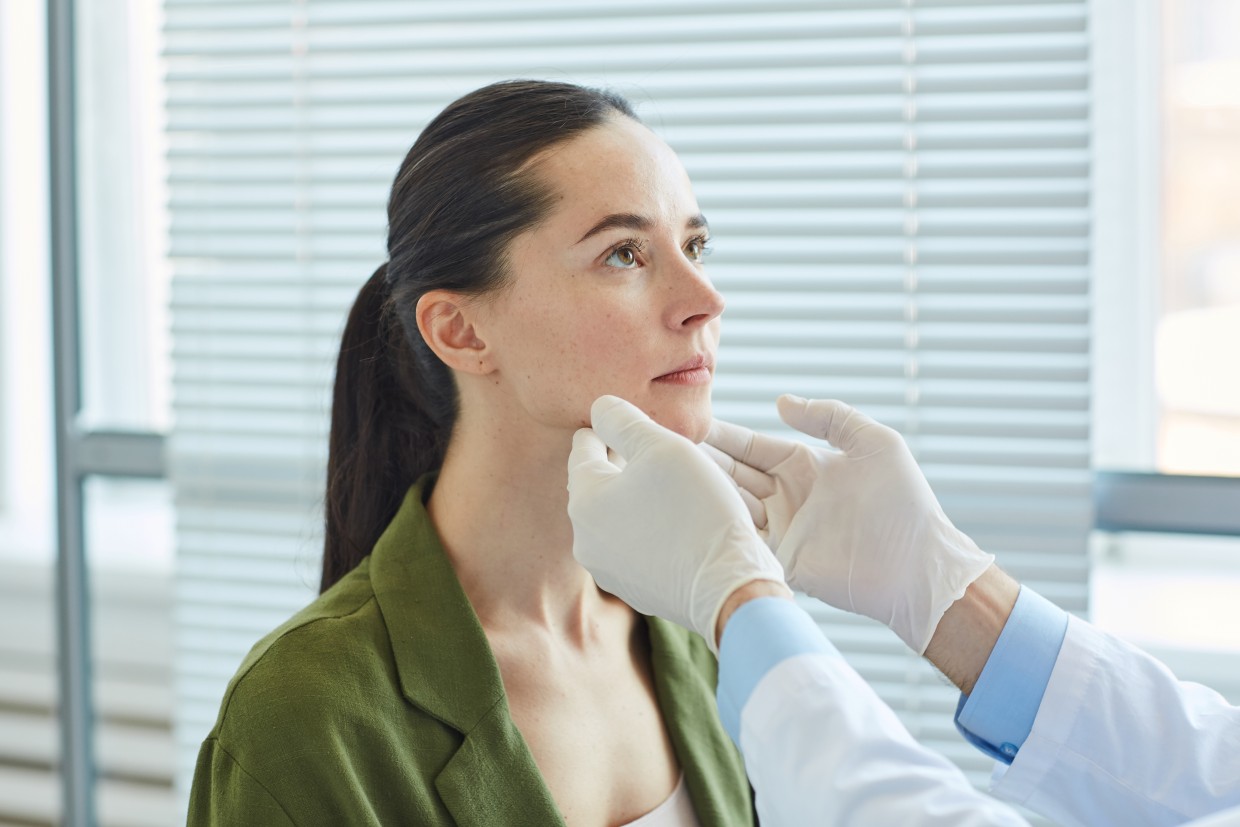 Dental professional examining a patient's jaw during an evaluation for TMJ symptoms