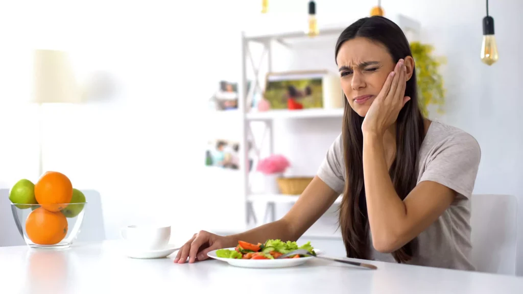 Woman experiencing tooth pain and seeking emergency dental care