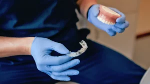Clear Invisalign aligner being handled at Liesen Family Dental in Collinsville, IL